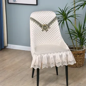 Detailed view of quilted lace chair cover, elegant floral embroidery for home dining room use.
