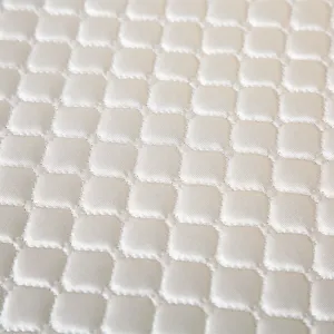 Close-up detail of quilted chair cushion fabric, soft silky texture with elegant grid pattern.