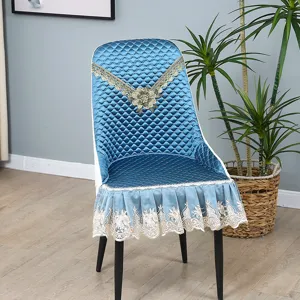 Detailed view of blue quilted dining chair cover with elegant lace and floral embroidery.