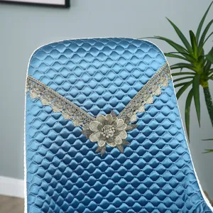 Blue quilted chair cover featuring elegant lace trim and floral embroidery for home decor detail.