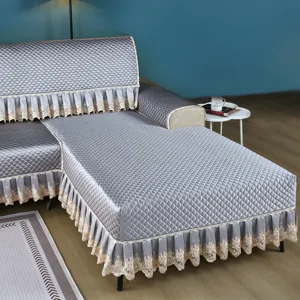 Quilted sofa cover detail showcasing thick padded fabric and elegant lace skirt trim for home.