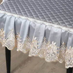 Close-up detail of quilted grey chair cushion featuring elegant pleated lace embroidered skirt.