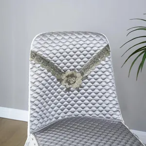 Detail view of luxury quilted chair cover in silver grey with elegant lace floral embroidery.