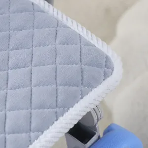 Vue détaillée du tissu de coussin pour chaise d'étudiant en velours matelassé et bordure tressée.