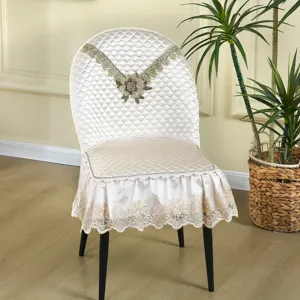 Eleganter beiger gesteppter Esszimmerstuhlbezug mit zarter Spitzenstickerei und Rüschensaum.