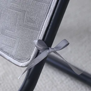 Close-up detail of grey chair cushion featuring textured fabric and elegant ribbon tie.