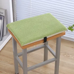 Dettaglio cuscino seduta in memory foam verde strutturato mostrato su uno sgabello.
