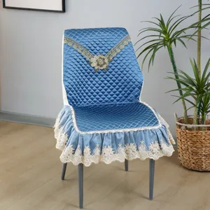 Blauwe gewatteerde eetkamerstoelhoes detail, kanten geborduurde rand, elegante inrichting.