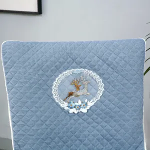 Gros plan détaillé de la housse de chaise matelassée bleue présentant un élégant motif brodé.