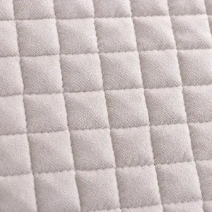 Gros plan détaillé montrant la texture matelassée et soignée du tissu de coussin de chaise.