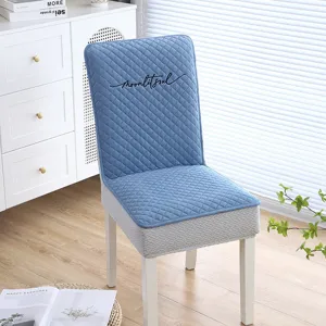 Détail en gros plan de la housse de chaise de salle à manger bleue matelassée avec broderie.