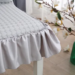 Fundas de silla de comedor de seda de hielo acolchada gris claro con detalle de volantes.