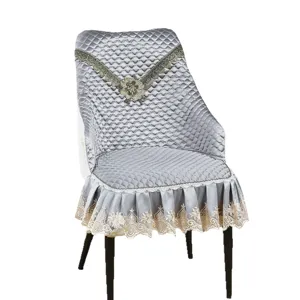 Fodera per sedia da pranzo grigia trapuntata con elegante bordo in pizzo raffinato.
