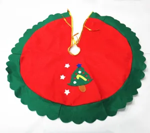 Detail view of red Christmas tree skirt with green scalloped edge and appliqué decor