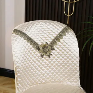 Housse de chaise de salle à manger incurvée matelassée avec broderie en dentelle dorée.