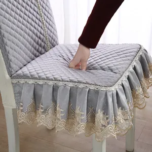 Vue détaillée de la housse de chaise de salle à manger grise matelassée avec belle dentelle.