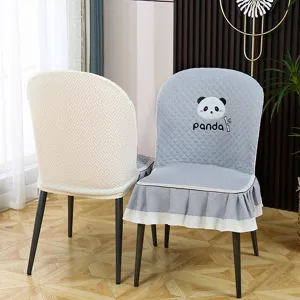 Vue détaillée de housses de chaise de salle à manger matelassées avec broderie panda et volants.