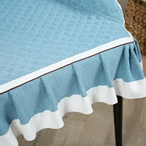Fodera per sedia trapuntata blu con gonna a volant bianca, dettaglio cuscino cotone.