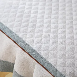 Détail de housse de chaise de salle à manger matelassée, motif losanges gris et bordure.