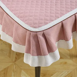 Détail de housse de chaise matelassée rose, texture douce avec bordure blanche et jupe plissée.