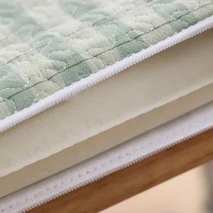 Close-up detail view of memory foam seat cushion interior, green plaid cover, white zipper.