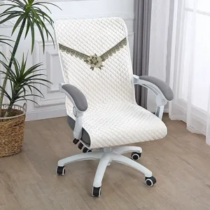 Detailed view of quilted office chair cover with elegant floral embroidery, white fabric.
