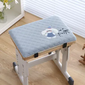 Detailed view of blue quilted student chair cushion with cute embroidered bunny and straps.