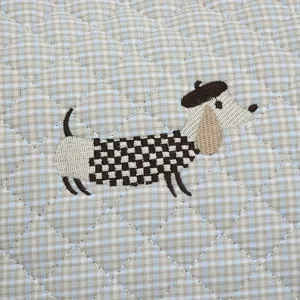 Vue détaillée du coussin de chaise à bascule matelassé à carreaux avec broderie teckel.
