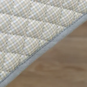 Vue en gros plan détaillée du coussin de chaise à bascule matelassé à carreaux bleus.