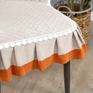 Housse de chaise de salle à manger matelassée avec dentelle blanche et bord orange élégant.