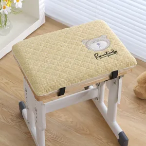 Student desk stool with yellow checkered cushion and cute bear embroidery for comfort.