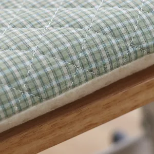 Detail view of green and white plaid quilted seat cushion with thick foam filling.
