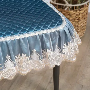 Housse de chaise en velours bleu avec bordure en dentelle blanche et ourlet brodé.