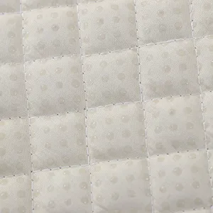 Gros plan sur les details du tissu matelassé et des points antidérapants pour coussin.
