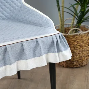 Detailopname van lichtblauwe gewatteerde stoelhoezen met elegante witte randsel en volant.