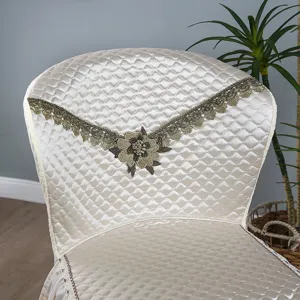 Détail de housse de chaise en satin matelassé, broderie florale en dentelle, luxe.