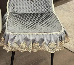 Gray quilted dining chair cover with elegant lace trim and gold embroidery for home decor.