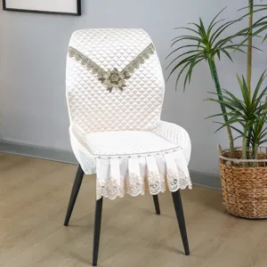 Vue détaillée de housse de chaise matelassée beige avec broderie florale et dentelle.