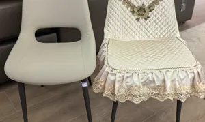 Quilted dining chair cover with elegant floral embroidery and ruffled skirt for home decor.