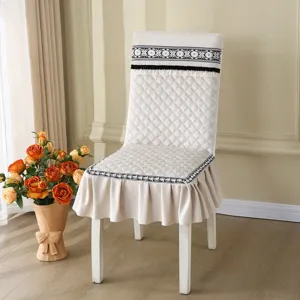 Vue détaillée de la housse de chaise matelassée avec une bordure en dentelle élégante.