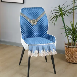 Vue détaillée de la housse de chaise de salle à manger matelassée bleue avec broderie en dentelle.