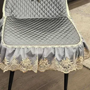Grey quilted dining chair cushion cover with elegant gold embroidered lace trim detail.