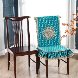 Vista detallada de funda de silla acolchada turquesa con bordado dorado y encaje.