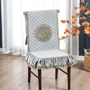 Elegante funda de silla acolchada gris con ribete de encaje dorado y bordado exquisito.
