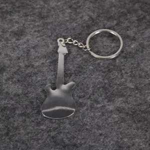 Detalle de un llavero de metal plateado con forma de bajo sobre un fondo de fieltro gris