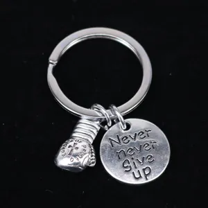 Close-up van bokshandschoen sleutelhanger met Never Give Up gegraveerde schijf