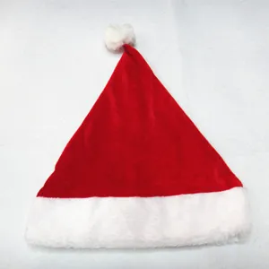 Detail van een klassieke rode fluwelen kerstmuts met witte pluchen rand en pompon.