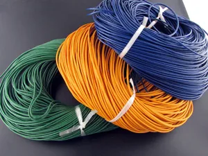 Detailed view of green, orange, and blue round cowhide leather cords for DIY jewelry.