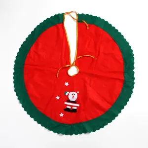 Détail de jupe de sapin de Noël rouge et verte avec une applique de Père Noël mignonne