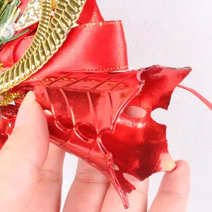 Detailed macro shot of a red metallic Christmas bell pendant showing material texture